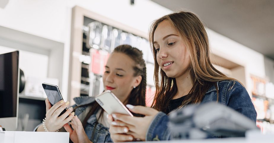Servicio técnico de celulares en Quito | Centro Comercial Caracol Dos usuarias comparando celulares en una tienda de tecnología.